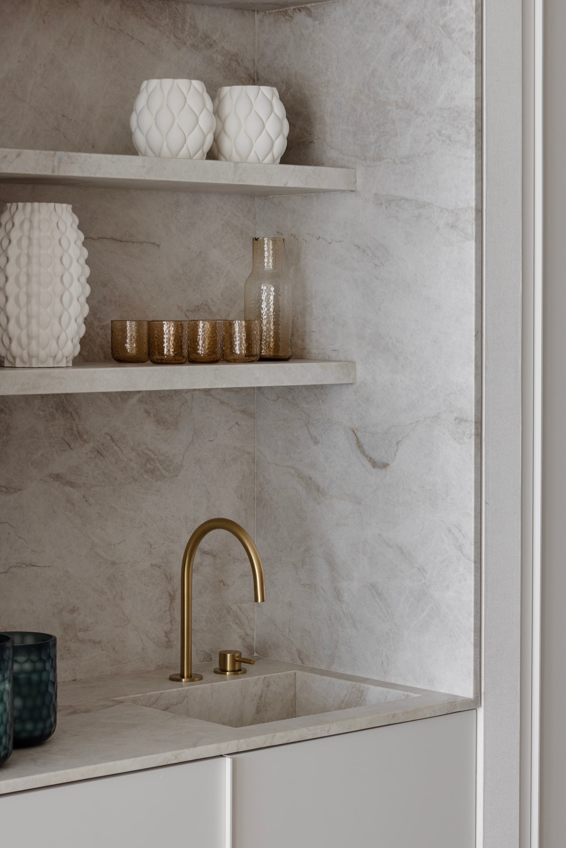 Wet bar with marble shelving and brass tap