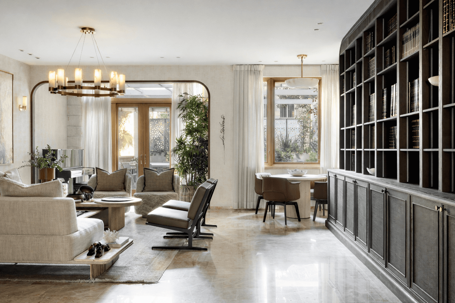 Luxury living room with dark wood bookshelves and polished stone floors by Wolff Construction