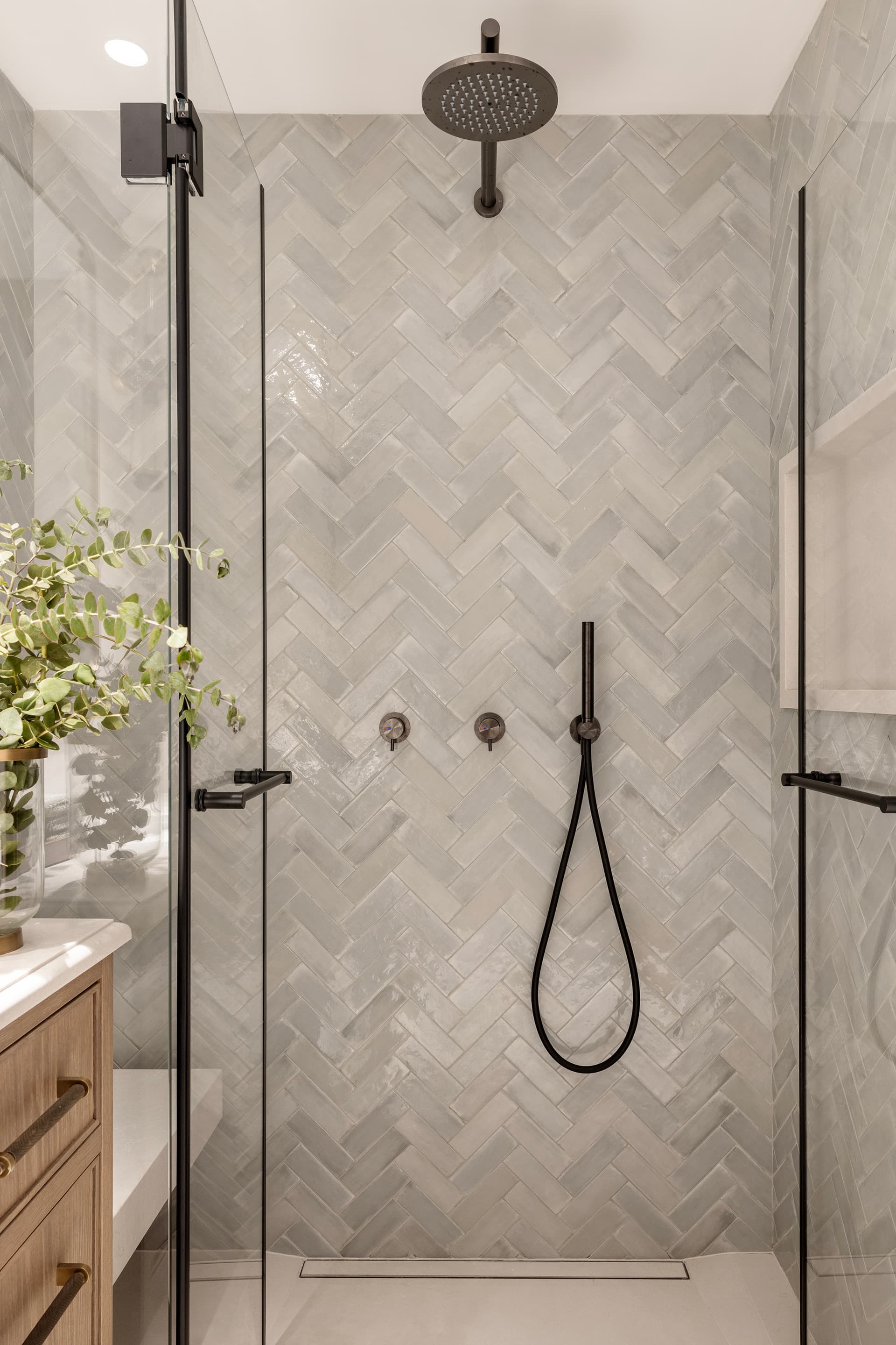 Shower with herringbone tile and dark fittings